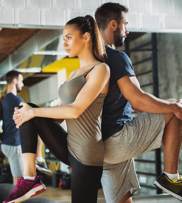Mein Weg zur Frau, Paar im Fitnessraum steht Rücken an Rücken